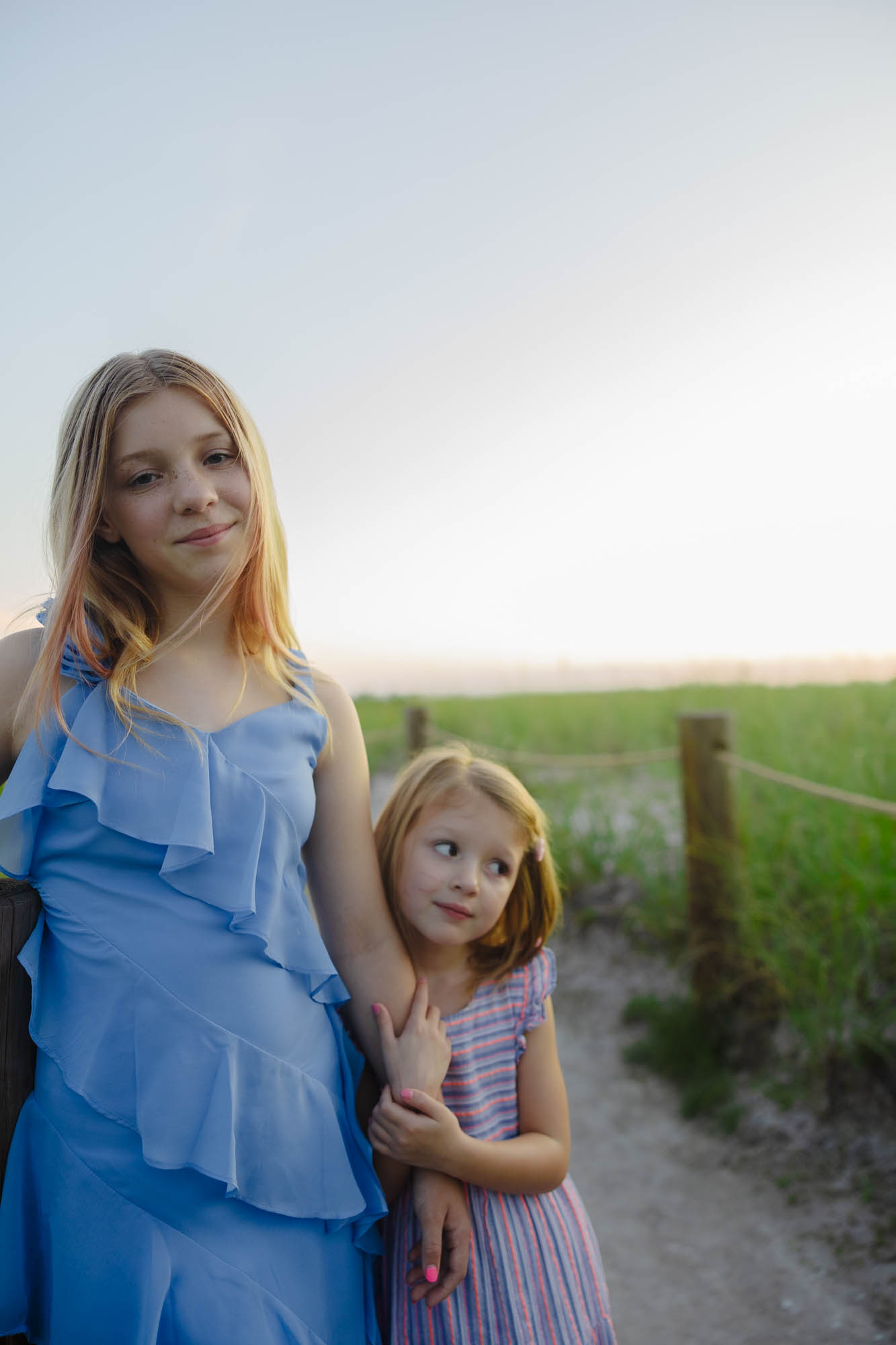 Two sisters in seagrass, warm light